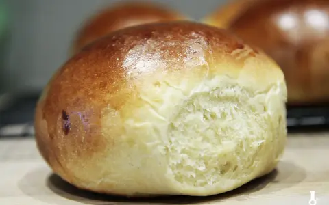 Złociste bułeczki brioche z widocznym, puszystym wnętrzem.