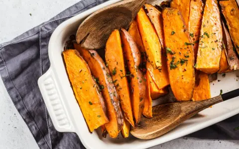 Pieczone bataty w naczyniu, posypane ziołami. Idealne, by pomyśleć co do batatów na obiad.