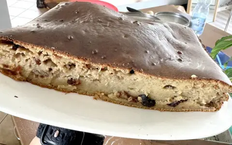 Sernik z polewą czekoladową, który opadł. Widać jego wilgotne wnętrze z bakaliami. Zastanawiasz się, dlaczego sernik opada?