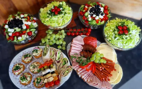 Pyszne przekąski i sałatki na talerzach. Zastanawiasz się, ile kosztuje catering do domu? To idealna opcja na imprezę!