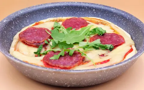 Pizza salami z rukolą w patelni.