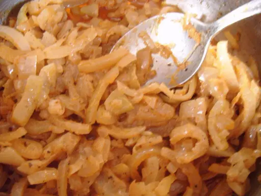 Smażona cebula z przyprawami, wygląda jak pyszna omasta do pierogów.