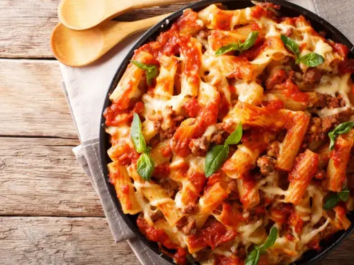 Pyszne danie z makaronem rigatoni, sosem pomidorowym i mięsem mielonym, zapieczone z serem. Idealne co na obiad z mięsa mielonego.