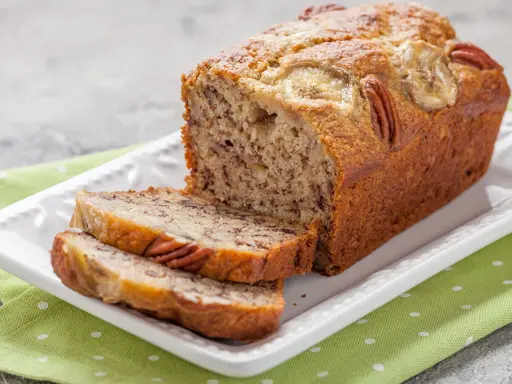Chlebek bananowy Ani gotuje się wspaniale, z orzechami pekan i plasterkami banana na wierzchu.