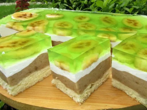 Warstwowy deser z biszkoptem, kremem, bananami i galaretką. Pyszne wilgotne ciasto bananowe z owocami.