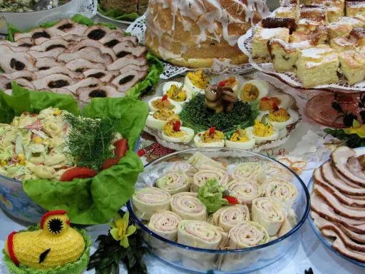 Mnóstwo pyszności na stole, idealnych na to, co ugotować na święta: pieczone mięsa, sałatki, jajka faszerowane, babka i ciasta.