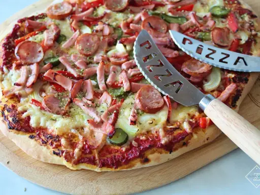 Pyszna pizza z kiełbasą i warzywami, gotowa do pokrojenia. To najlepsza pizza przepis, jaki kiedykolwiek próbowałeś!