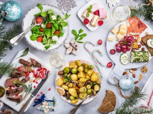 Wigilia na talerzu: pieczone ziemniaki, mięso, sałatka, ser, słodkości. Zastanawiasz się, ile kosztuje catering na wigilię?