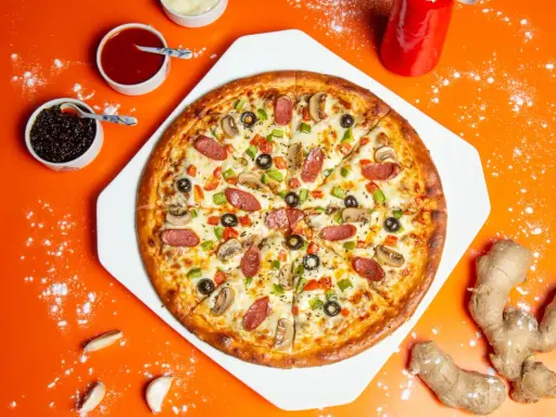Chrupiąca pizza z pieczarkami, salami i papryką na pomarańczowym tle.
