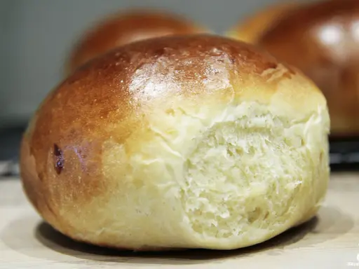 Złociste bułeczki brioche z widocznym, puszystym wnętrzem.