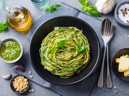 Pyszne spaghetti z pesto to idealna odpowiedź na pytanie: co zrobić na obiad bezmięsny. Podane z parmezanem i świeżą bazylią.