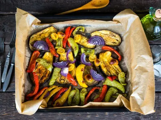Kolorowe warzywa pieczone w piekarniku: bakłażan, papryka, cebula i pomidorki.