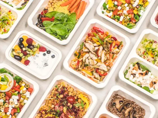 Catering dietetyczny co to? Różnorodne, zdrowe posiłki w wygodnych pojemnikach: sałatki, dania z kurczakiem, kaszą, owocami i warzywami.