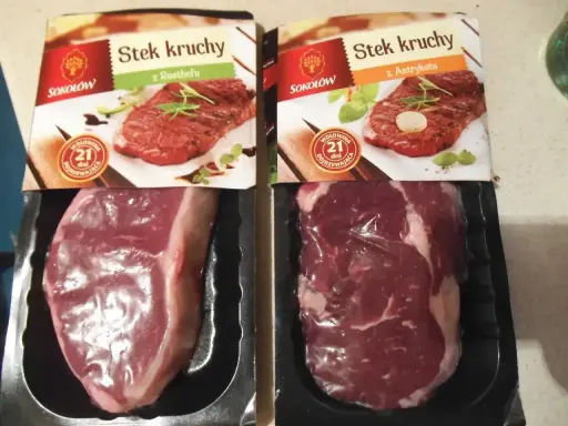 Dwa opakowania steka wołowego z widocznymi surowymi mięsami i zdjęciami gotowych steków.