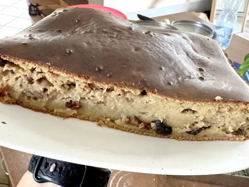 Sernik z polewą czekoladową, który opadł. Widać jego wilgotne wnętrze z bakaliami. Zastanawiasz się, dlaczego sernik opada?