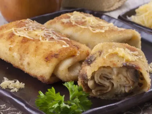Idealne co na obiad w poniedziałek: złociste krokiety z pieczarkami i serem, posypane startym parmezanem, udekorowane natką pietruszki.