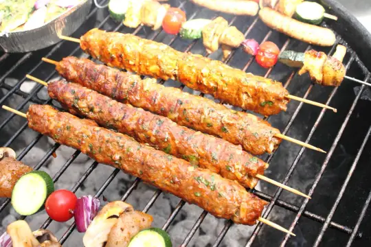 Szaszłyki z mięsa mielonego, soczyste i aromatyczne, pieką się na grillu obok warzyw.