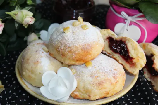 Szybkie pączki z piekarnika, oprószone cukrem pudrem, z pysznym dżemem w środku. Idealne na deser!