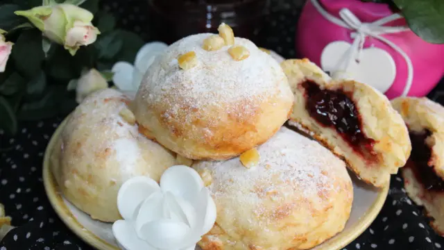 Szybkie pączki z piekarnika, oprószone cukrem pudrem, z pysznym dżemem w środku. Idealne na deser!