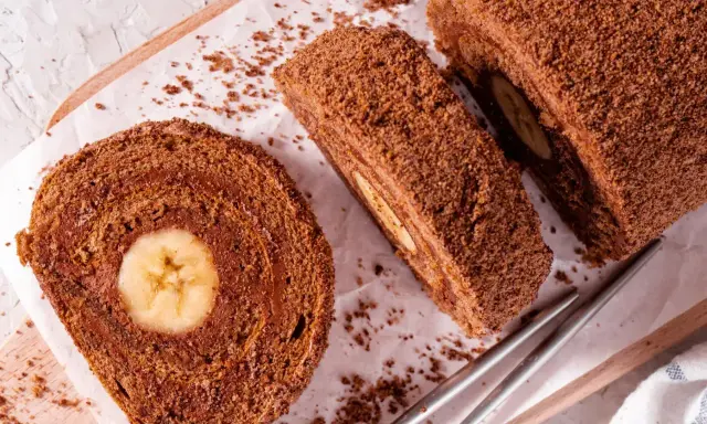 Czekoladowa, najprostsza rolada biszkoptowa z bananem w środku, posypana wiórkami. Idealna na deser.