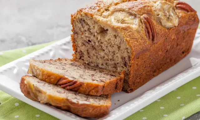 Chlebek bananowy Ani gotuje się wspaniale, z orzechami pekan i plasterkami banana na wierzchu.