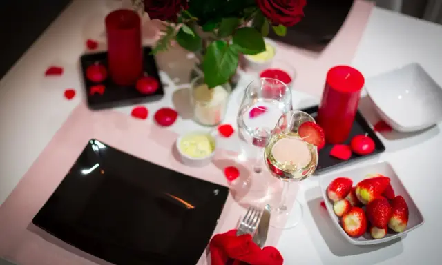 Romantyczna kolacja walentynkowa: czerwone róże, świece, wino i truskawki. Idealne inspiracje, co ugotować na walentynki.