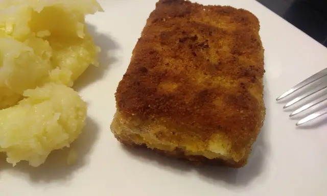Złociste, chrupiące kostki rybne mrożone w panierce, idealne do szybkiego obiadu. Podane z purée ziemniaczanym.