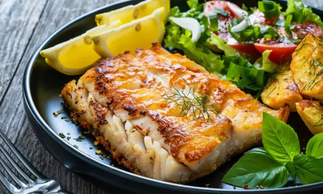 Idealny wybór, co do ryby na obiad: soczysty filet rybny z chrupiącymi ziemniaczkami, świeżą sałatką i cytryną.