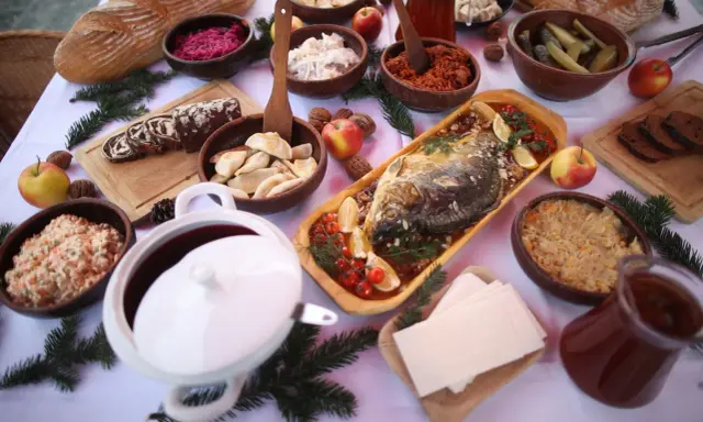 Wigilijny stół pełen smakołyków: karp, pierogi, kapusta, barszcz i chleb. Idealne inspiracje, co ugotować na Wigilię.