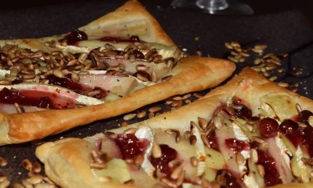 Ciasto francuskie z camembertem, gruszką i żurawiną, posypane słonecznikiem.