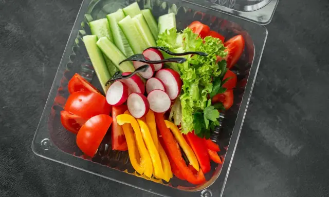 Świeże warzywa w pudełku – idealne na start, gdy zastanawiasz się, jak otworzyć catering dietetyczny. Pomidory, ogórki, rzodkiewki, papryka i sałata.