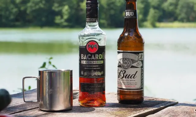 Bacardi Carta Negra i piwo Bud na drewnianym stole. Zastanawiasz się, jaki alkohol do tiramisu? Rum Bacardi to świetny wybór!