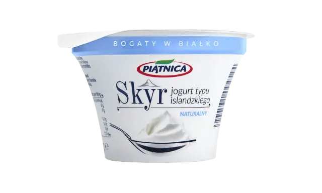 Opakowanie jogurtu typu islandzkiego Skyr Piątnica Naturalny z łyżką pełną jogurtu.