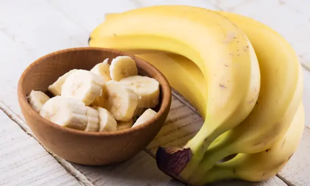 Banan wartości odżywcze: pyszne, żółte banany obok miseczki z pokrojonymi plasterkami. Idealne na zdrową przekąskę.