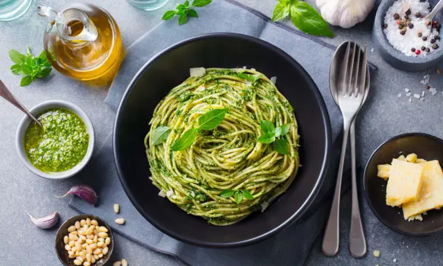 Pyszne spaghetti z pesto to idealna odpowiedź na pytanie: co zrobić na obiad bezmięsny. Podane z parmezanem i świeżą bazylią.