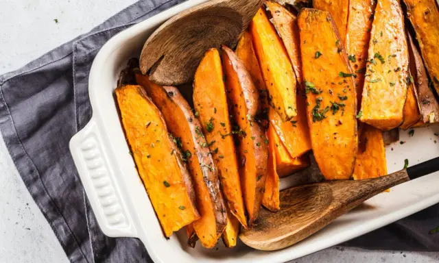 Pieczone bataty w naczyniu, posypane ziołami. Idealne, by pomyśleć co do batatów na obiad.