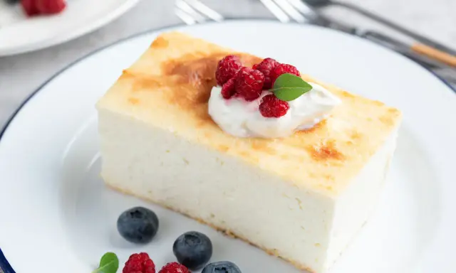 Puszysty sernik z malinami i bitą śmietaną. Idealny jaki aromat do sernika? Waniliowy lub cytrynowy.