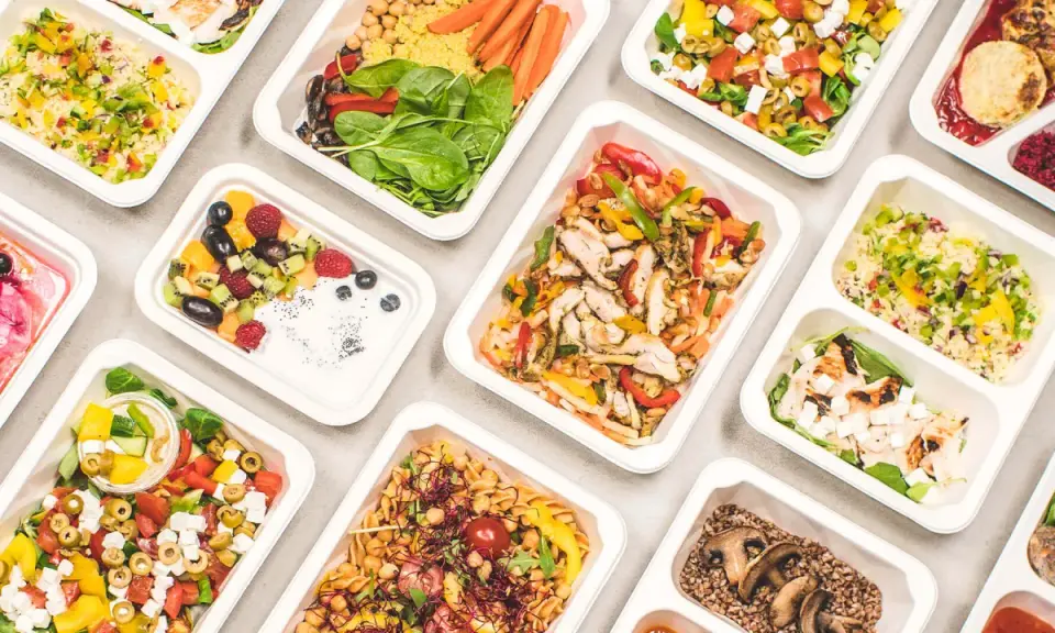Catering dietetyczny co to? Różnorodne, zdrowe posiłki w wygodnych pojemnikach: sałatki, dania z kurczakiem, kaszą, owocami i warzywami.