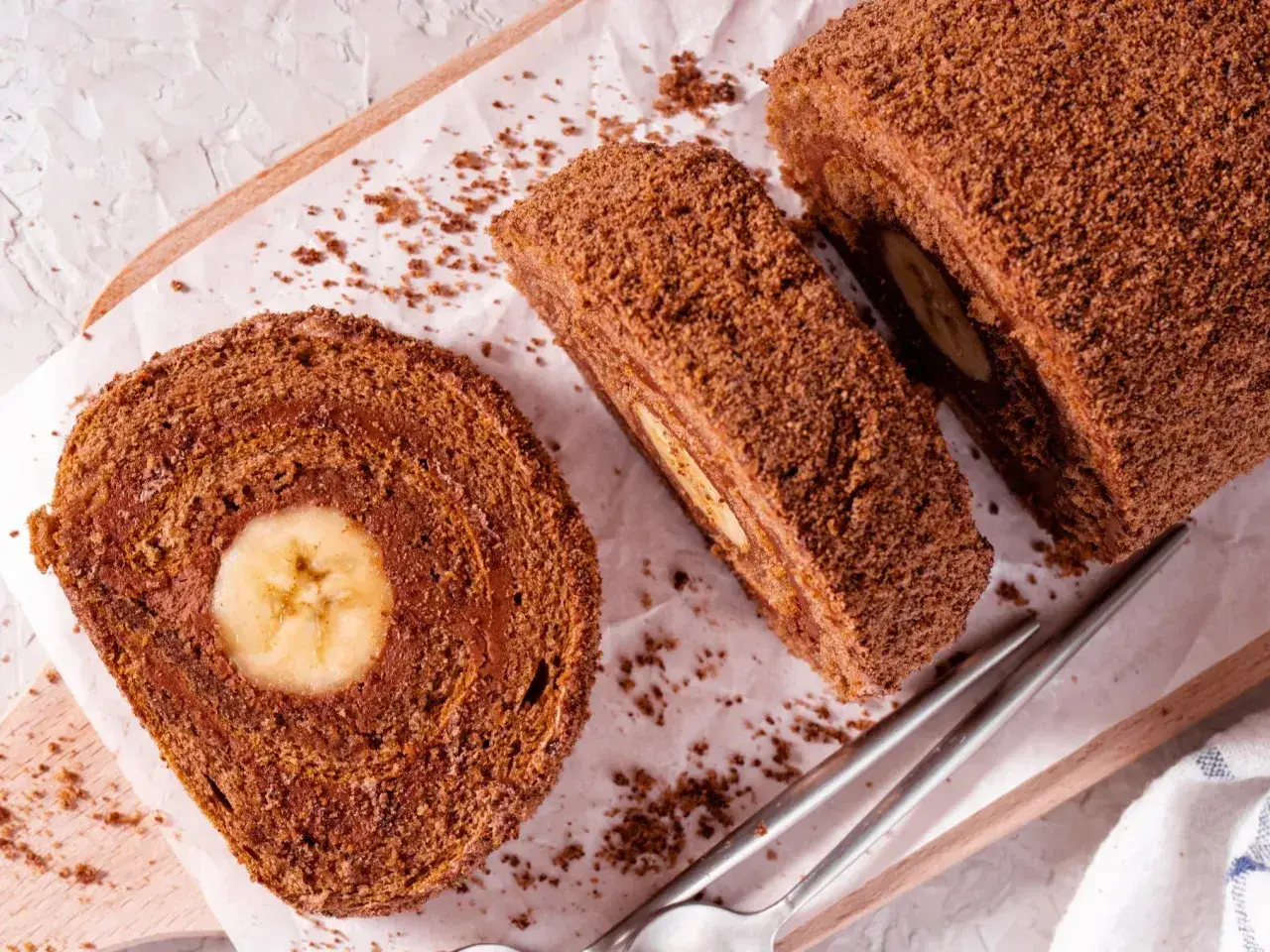 Czekoladowa, najprostsza rolada biszkoptowa z bananem w środku, posypana wiórkami. Idealna na deser.