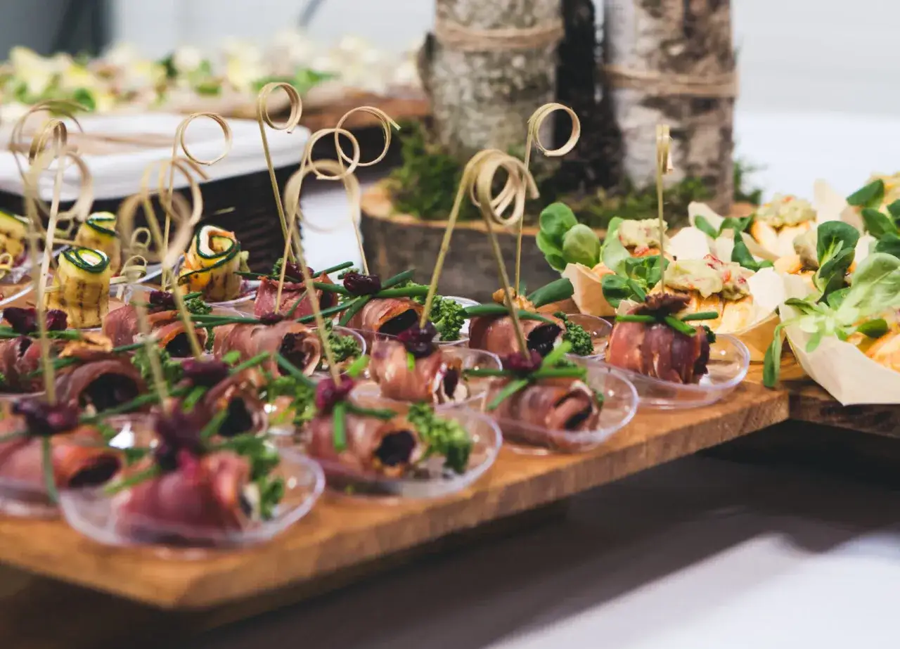 Wykwintne przekąski na drewnianej desce. To właśnie catering – małe dzieła sztuki kulinarnej.