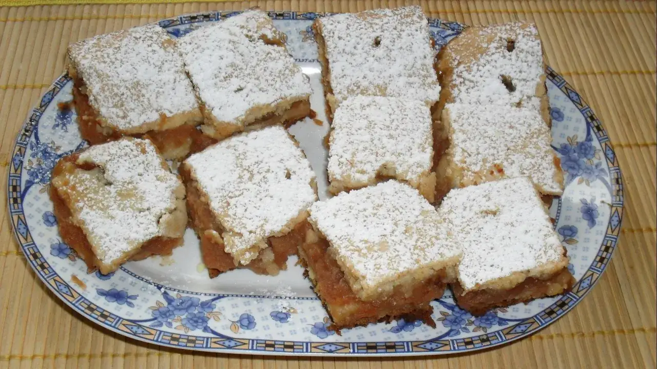 Pyszne ciasto z jabłkami, posypane cukrem pudrem. Idealne na podwieczorek, według prostych przepisów kulinarnych ciasta.