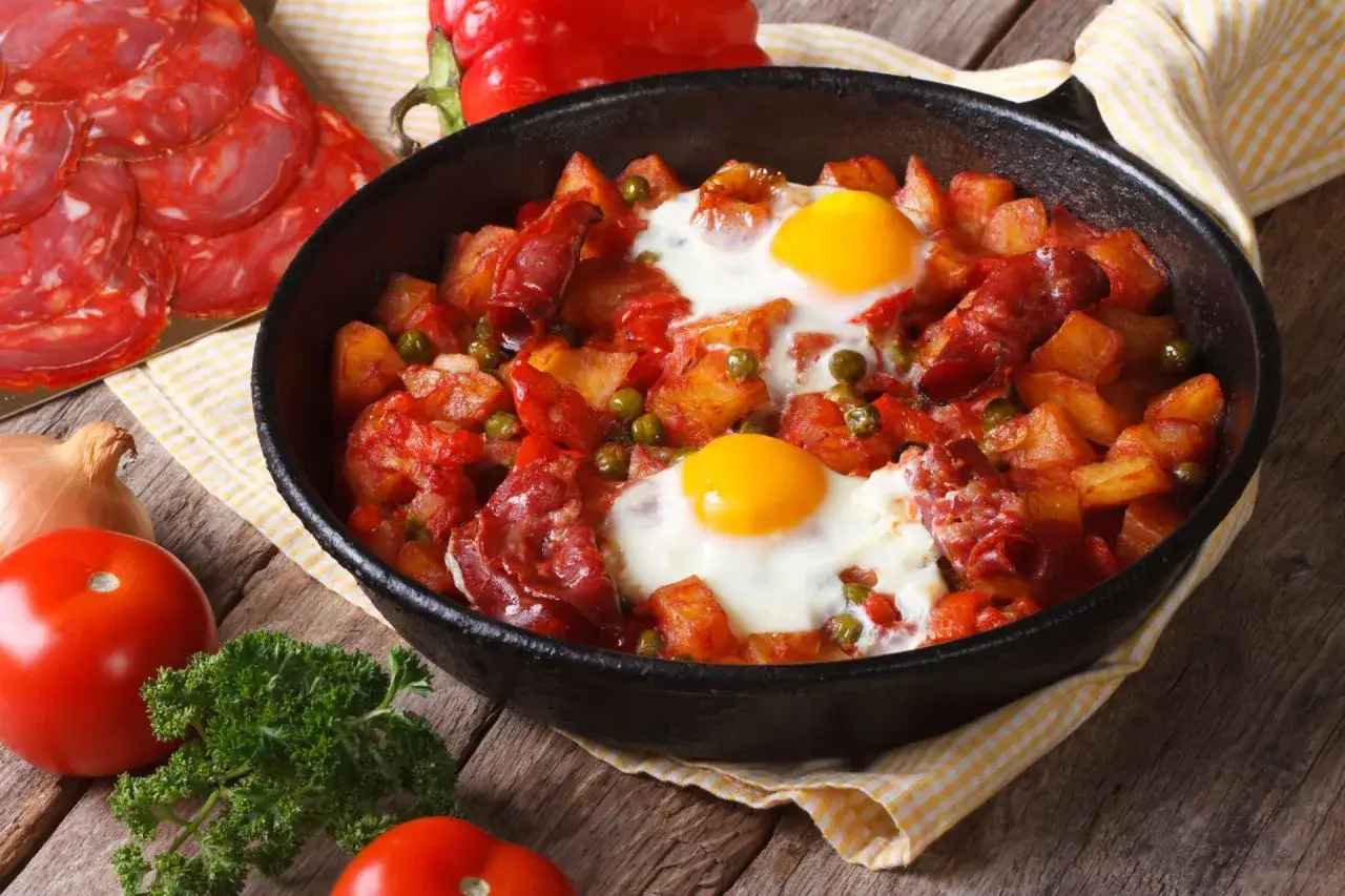 Pyszne danie z jajek na obiad: ziemniaki, chorizo i groszek w patelni. Idealne na sycący posiłek.