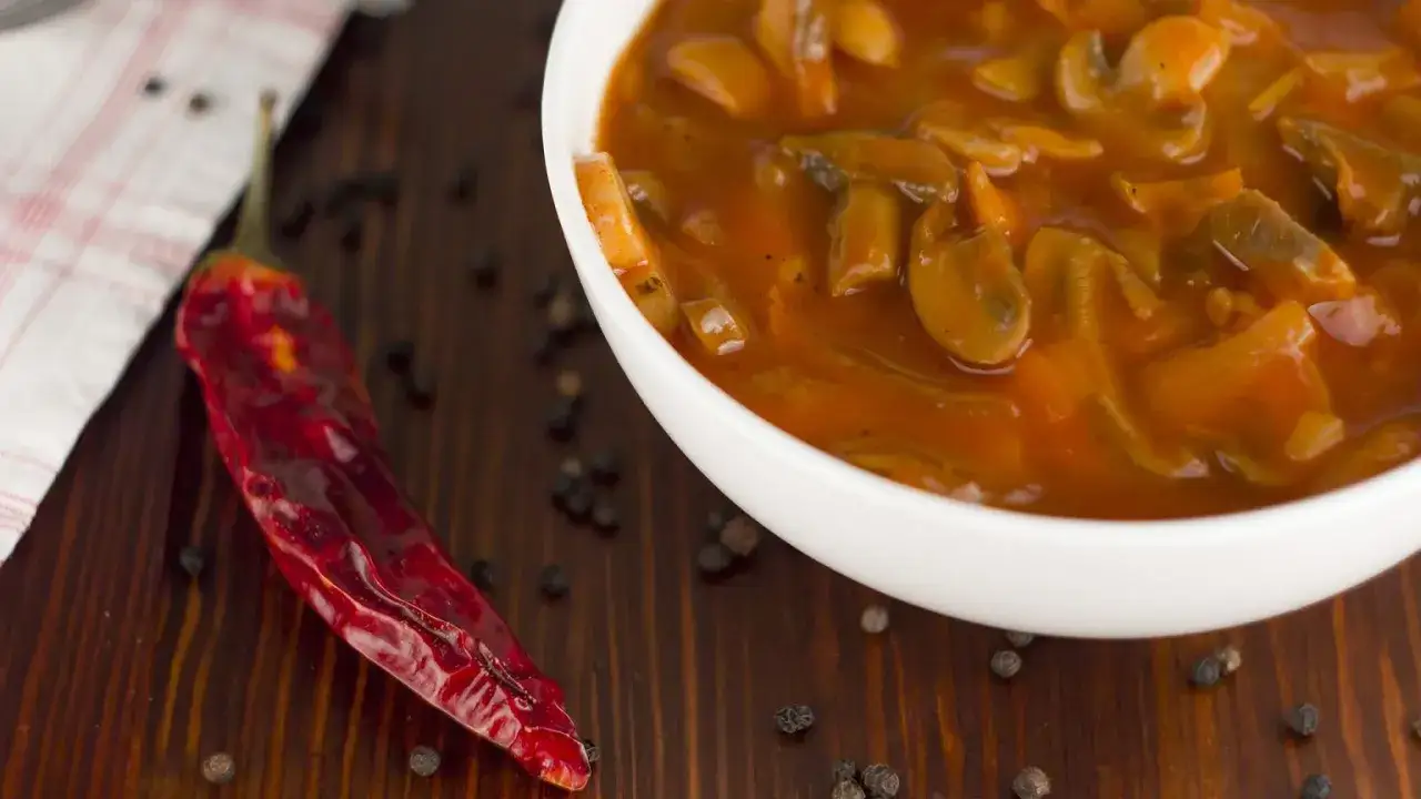 Gęsty sos grzybowy w misce, obok suszona papryczka chili i pieprz. Idealny dodatek, który podpowiada, co można ugotować.