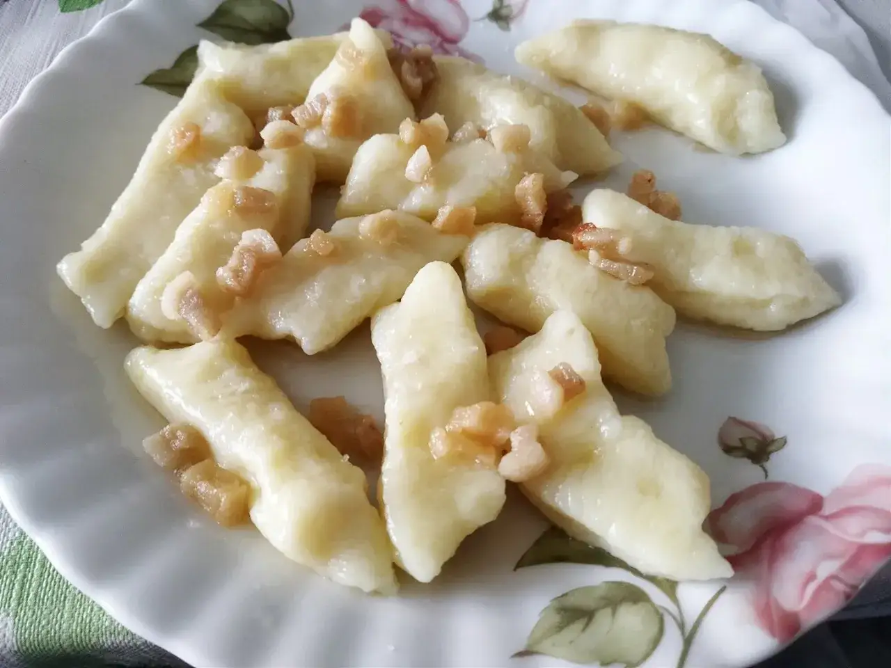 Pyszne kluski leniwe z ugotowanych ziemniaków, posypane skwarkami. Idealny pomysł, co zrobić z ugotowanych ziemniaków na szybki obiad.