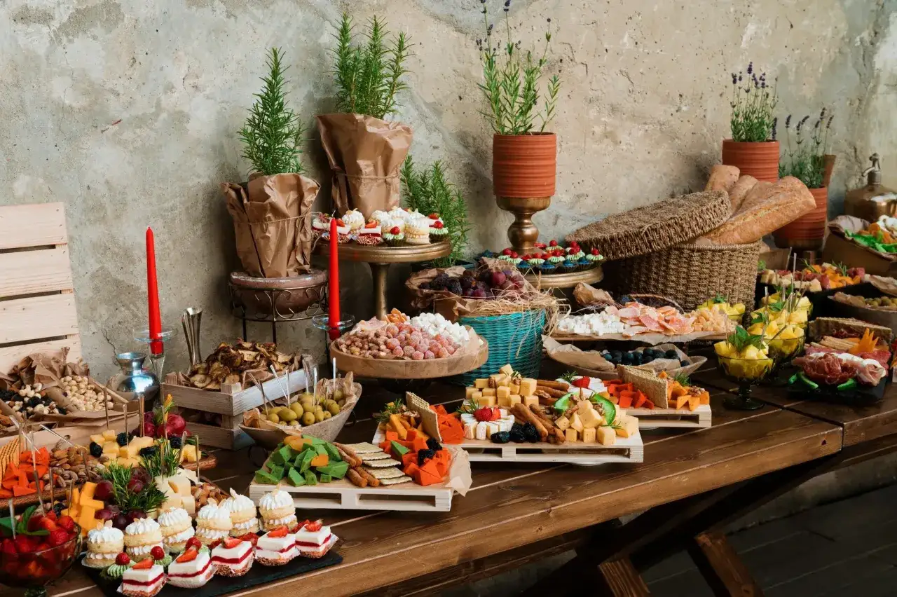 Bogaty st&oacute;ł z serami, owocami, ciastkami i pieczywem. Idealny na imprezę, zastanawiasz się, ile kosztuje catering na 18?