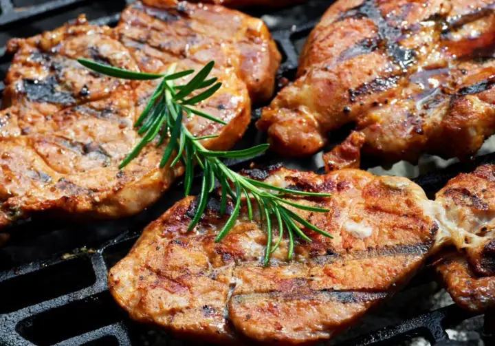 Soczysta karkówka z grilla, z aromatycznym rozmarynem, apetycznie rumieni się na ruszcie.